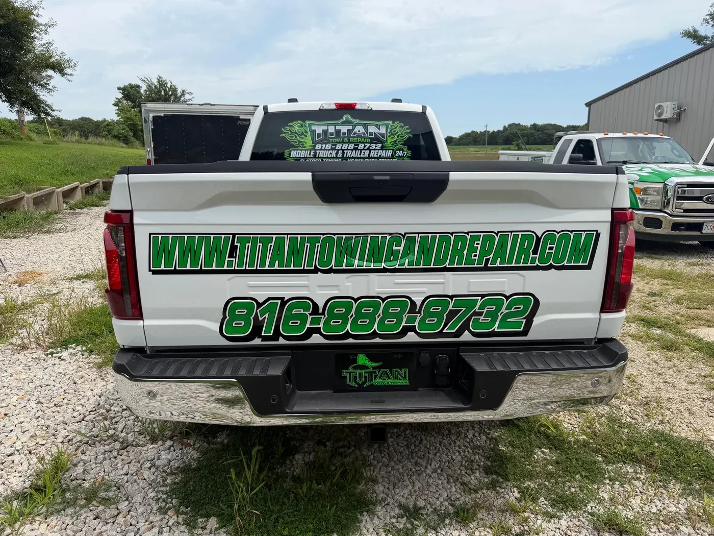 The back of a Titan Tow & Repair pickup showing the company phone number, 816-888-8732