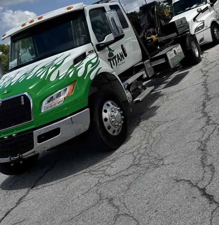 Titan heavy-duty wrecker in green flame livery, boom stowed.